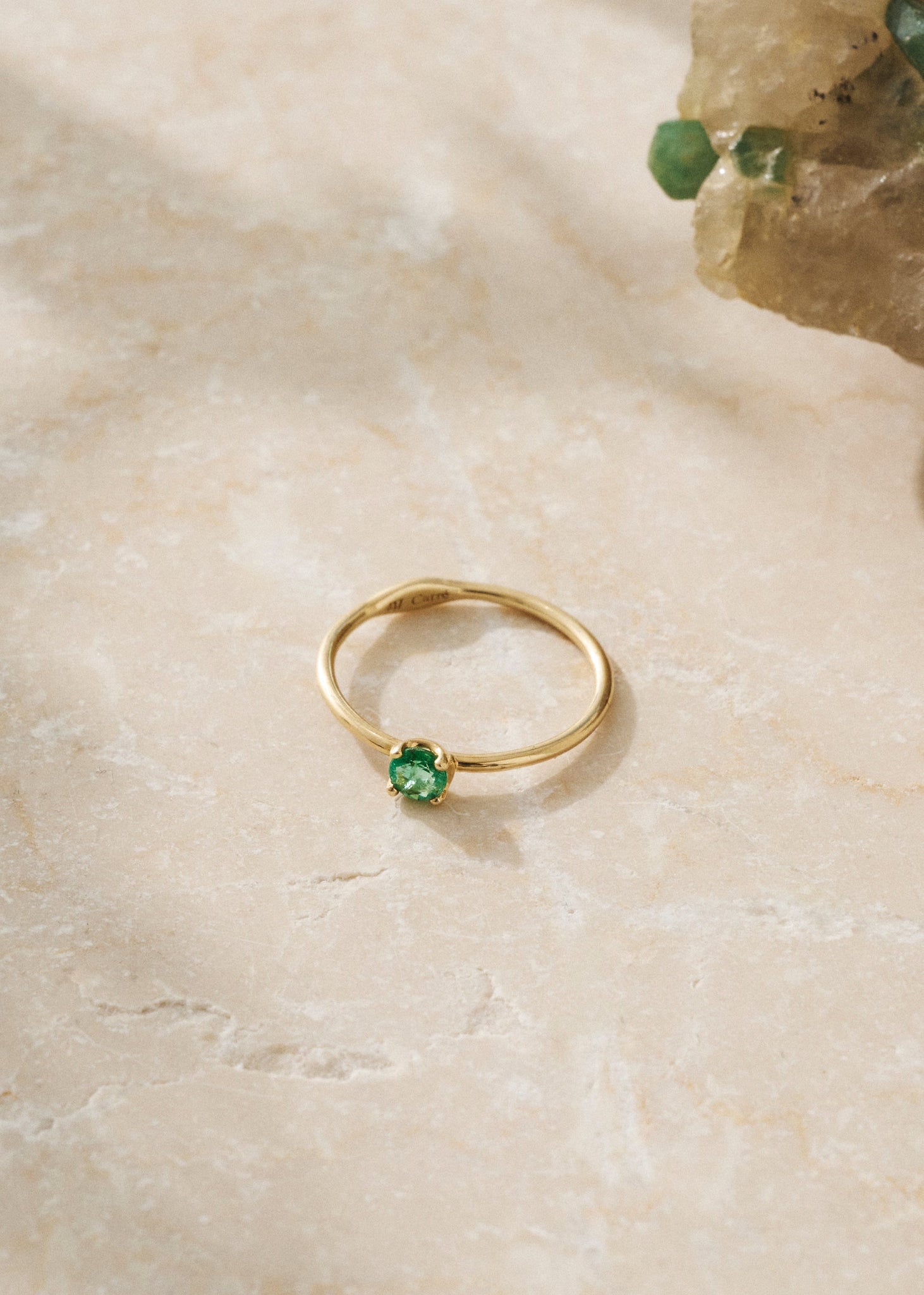 to ringe og en dobbelt ørestik med ædelsten i 18k guld. Alle er sat med smaragd