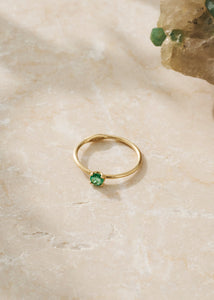to ringe og en dobbelt ørestik med ædelsten i 18k guld. Alle er sat med smaragd
