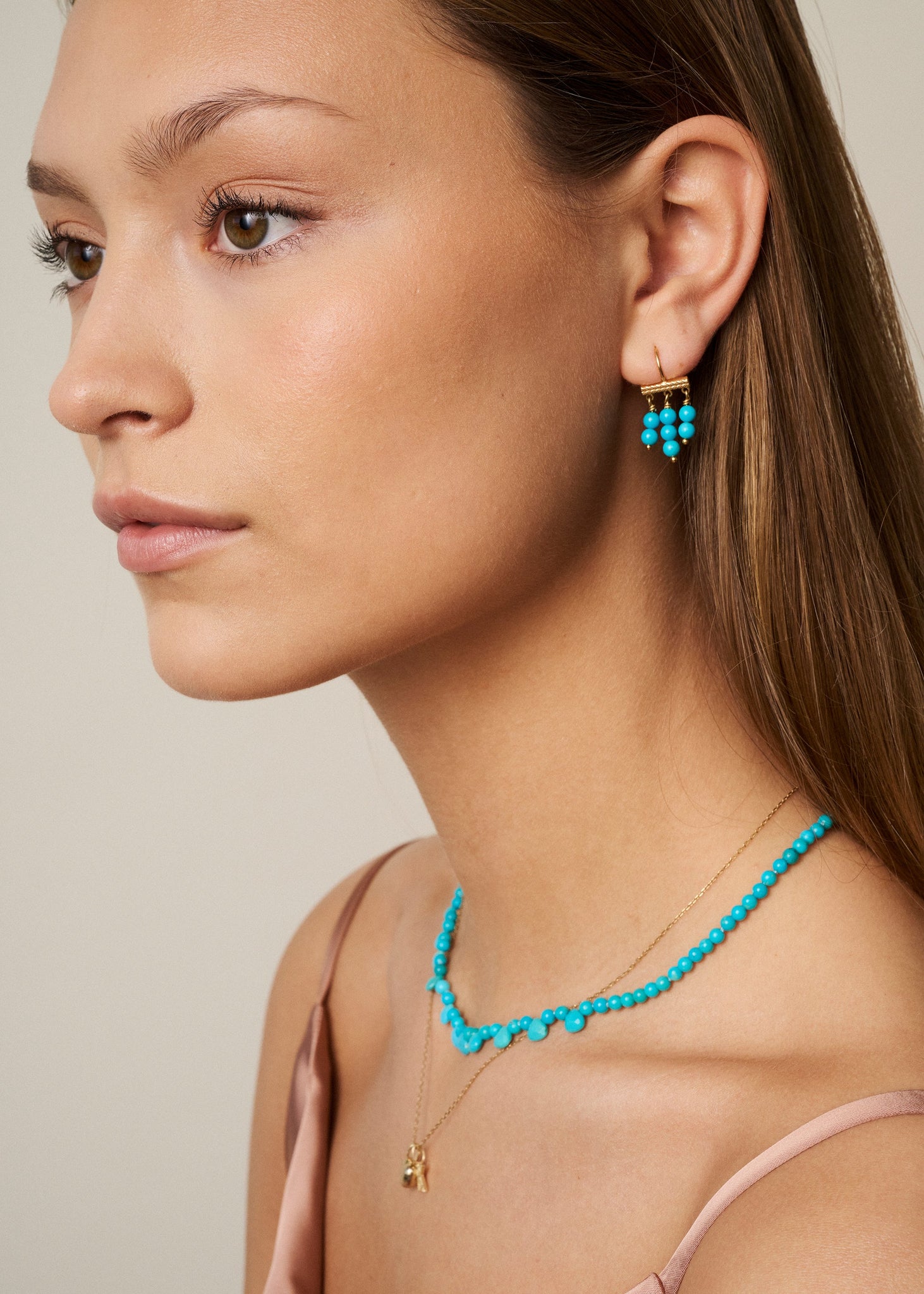 Ung kvinde med smykker fra carré jewellery med turkis ædelstenen, der er decembers fødselssten og symboliserer venskab