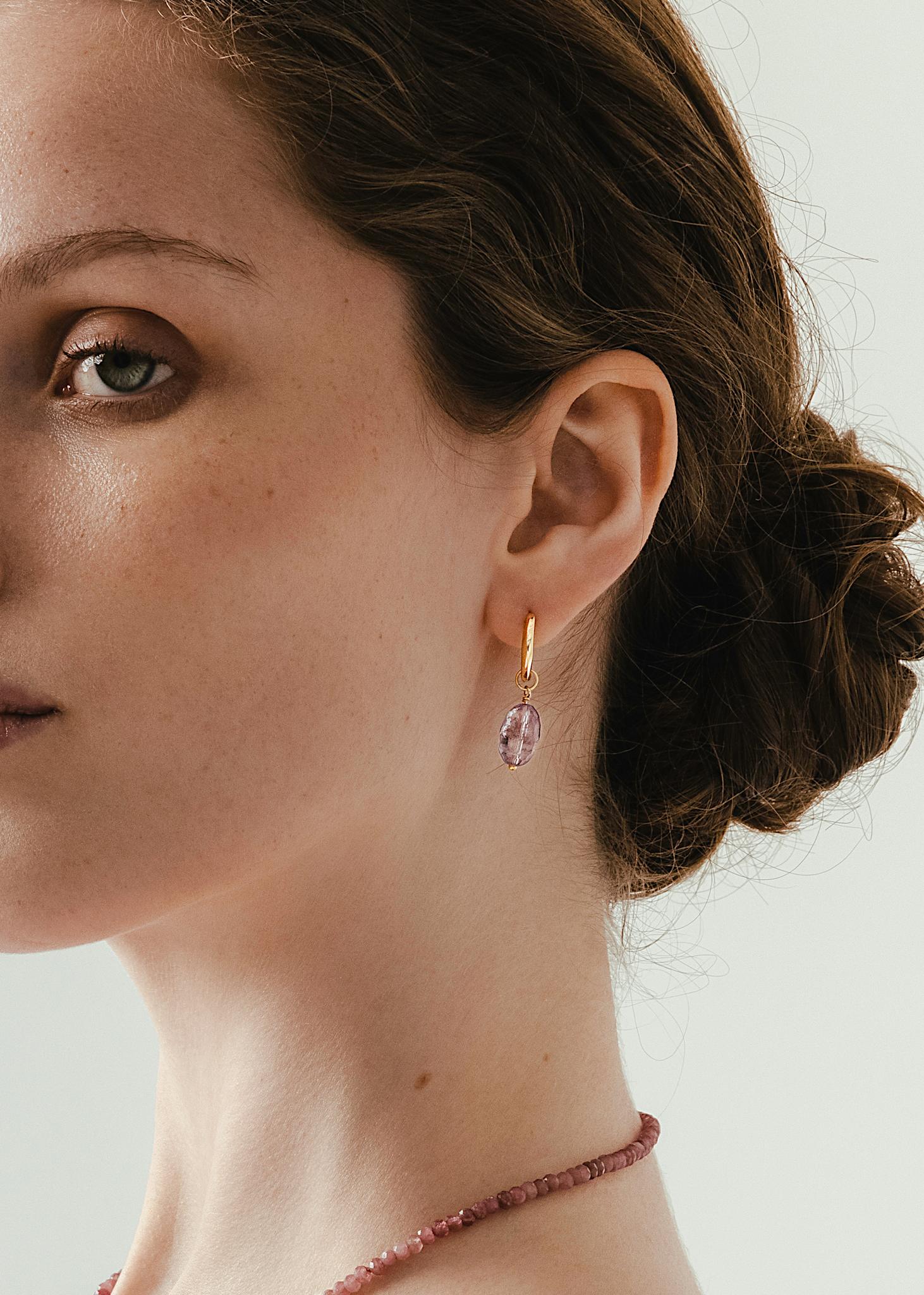 kvinde med hoop øreringe i guld med ametyst charms 