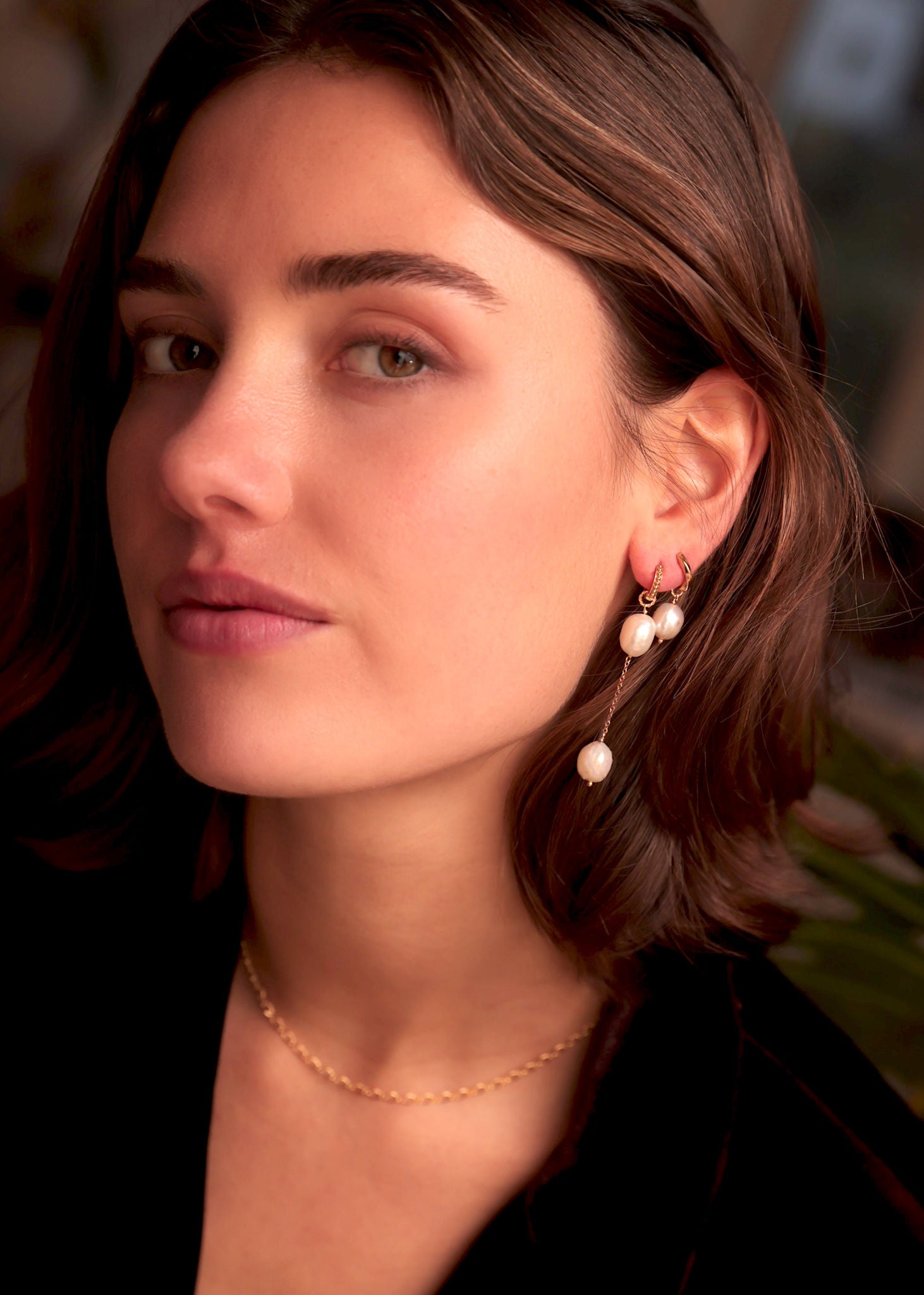 Kvinde med lange guld hængeøreringe med ferskvandsperler fra carré jewellery 