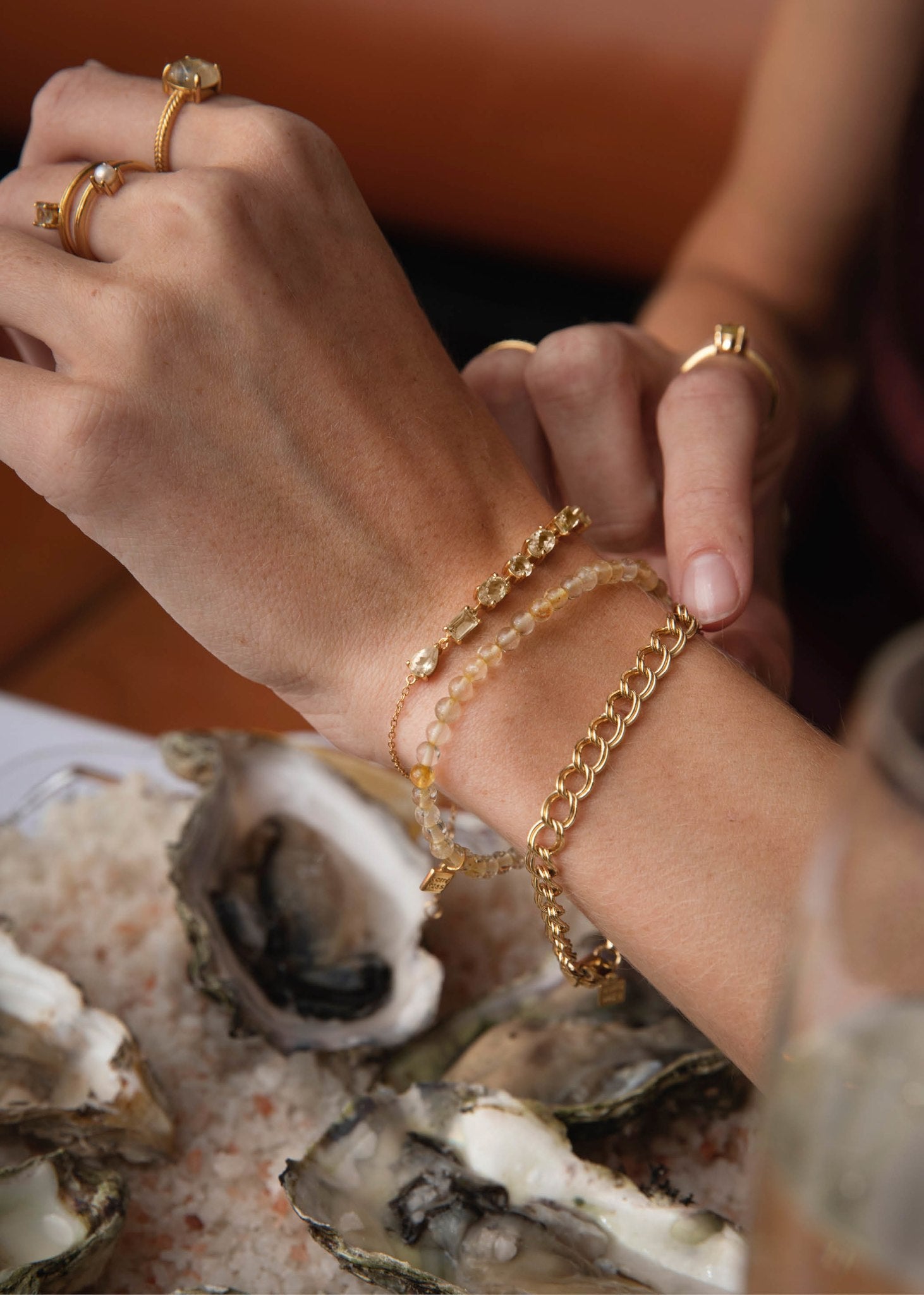 Kvinde med elegante spirituelle ædelstensarmbånd til mænd og kvinder i guldbelagt sterling sølv med rutil kvarts fra carré jewellery 
