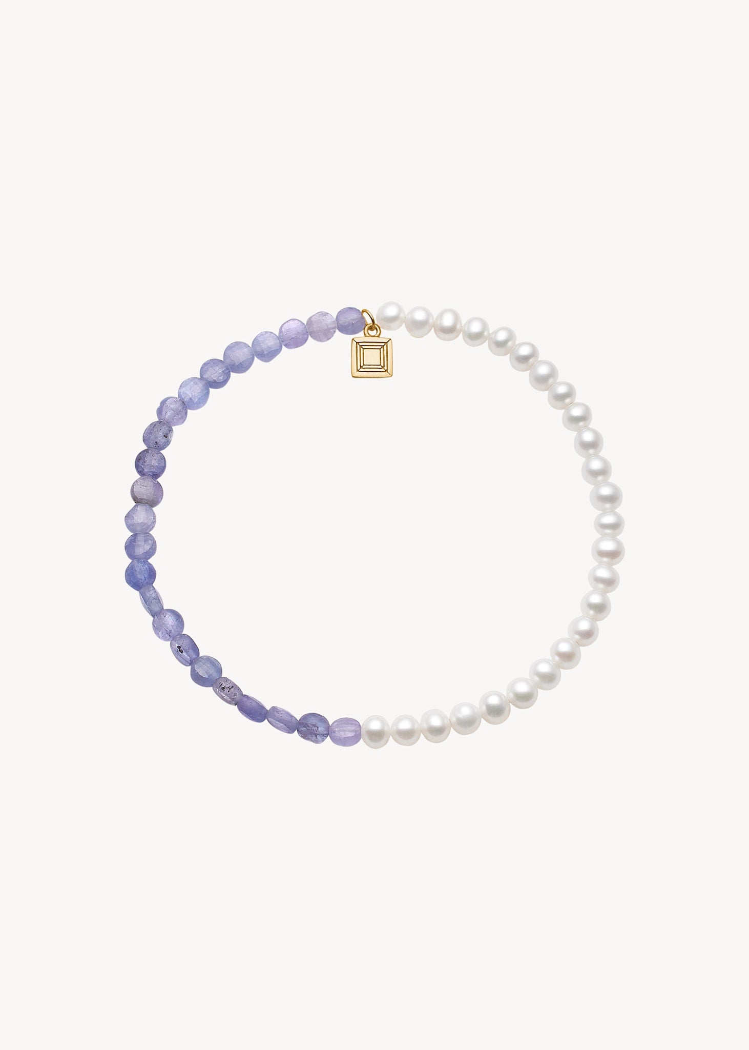 Håndlavet ædelstens armbånd fra carré jewellery lavet med genanvendte ædelsten sat med hvide ferskvandsperler og lilla tanzanit ædelsten til konfirmationen 2025