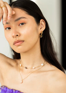 Ung kvinde med choker halskæde fra carré jewellery i guld med chunky ædelsten på figaro kæde 
