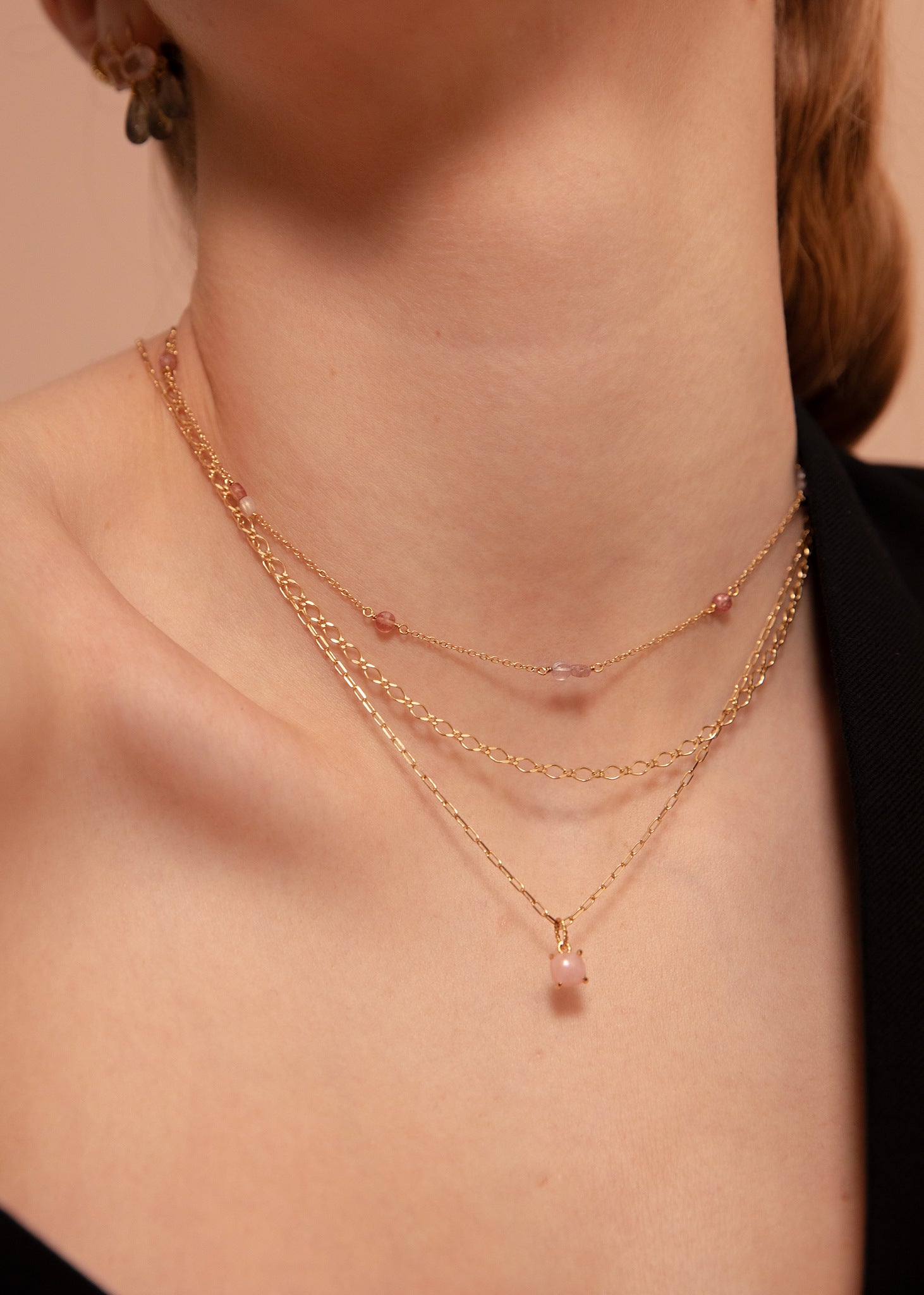 Kvinde med sød halskæde i guld med lyserøde spinel ædelsten på udsalg hos Carré Jewellery