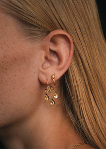 Kvinde med guld huggie hoops fra carré jewellery med champagne kvarts sten 