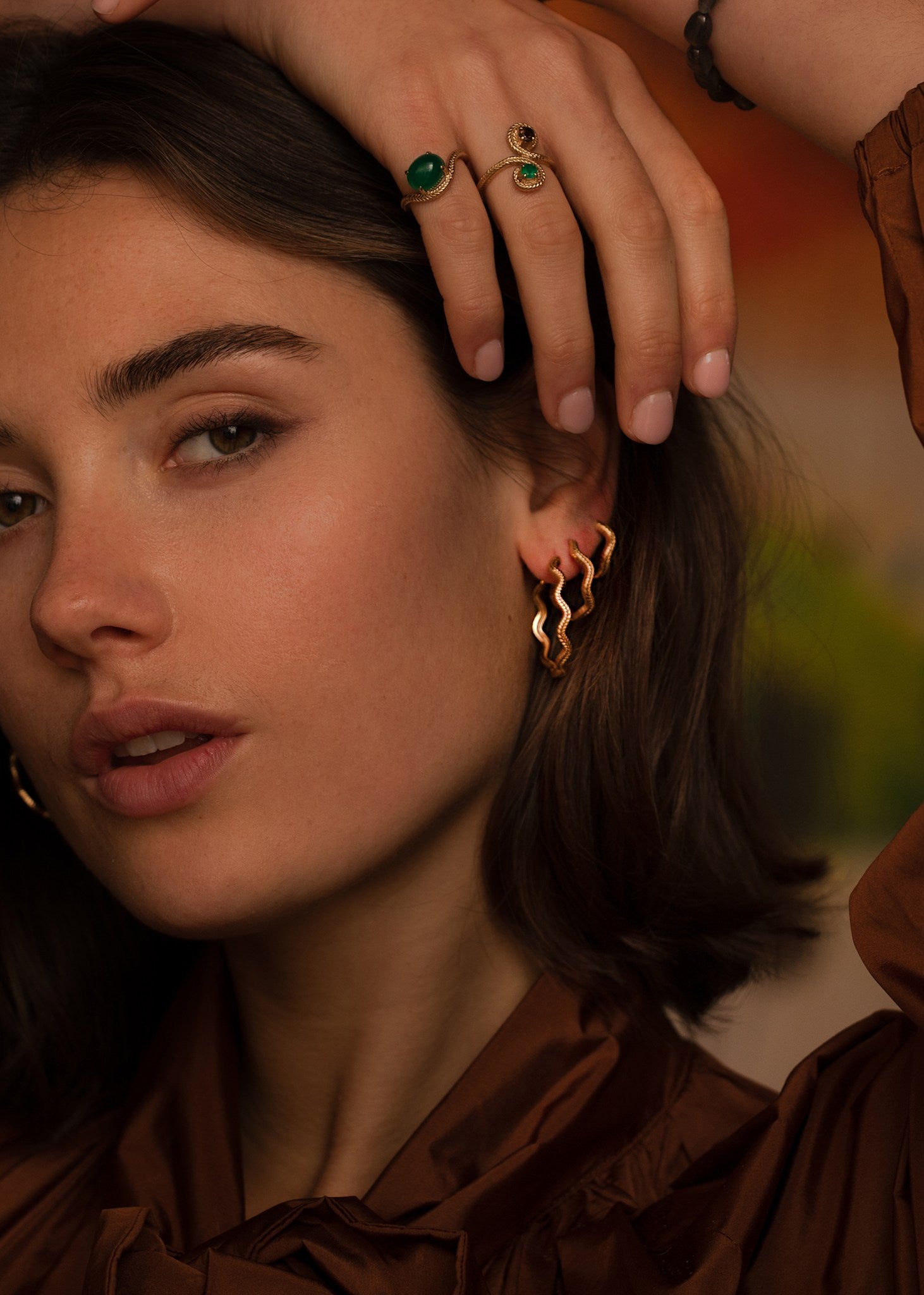 Kvinde med tre af carré jewellerys populære Wave hoops i forskellige størrelser i guldbelagt sterling sølv med creol lukning