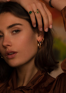 Kvinde med tre af carré jewellerys populære Wave hoops i forskellige størrelser i guldbelagt sterling sølv med creol lukning