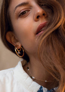 Kvinde med hoop øreringe i guld med labradorit charm til øreringe i guldbelagt sterling sølv fra carré jewellery 