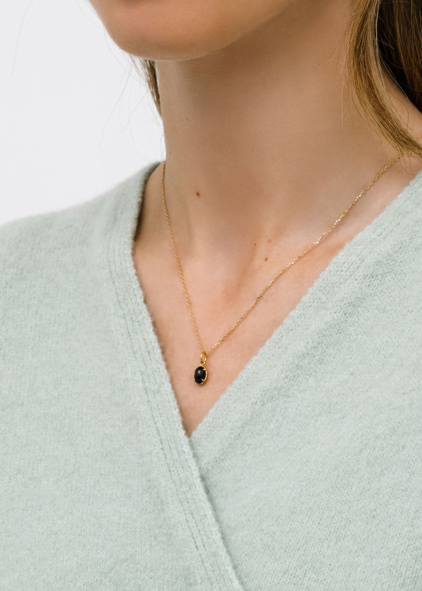 Kvinde med halskæde i guld på tilbud hos Carré Jewellery med ægte black star ædelsten 