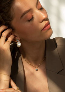 Ung kvinde med smykker i guldbelagt sterling sølv på tilbud hos Carré jewellery med blå topas ædelsten til ham og hende