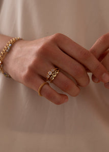 Kvinde med to ringe i guld fra carré jewellery med grønne sten og månesten ædelsten i sterling sølv på tilbud