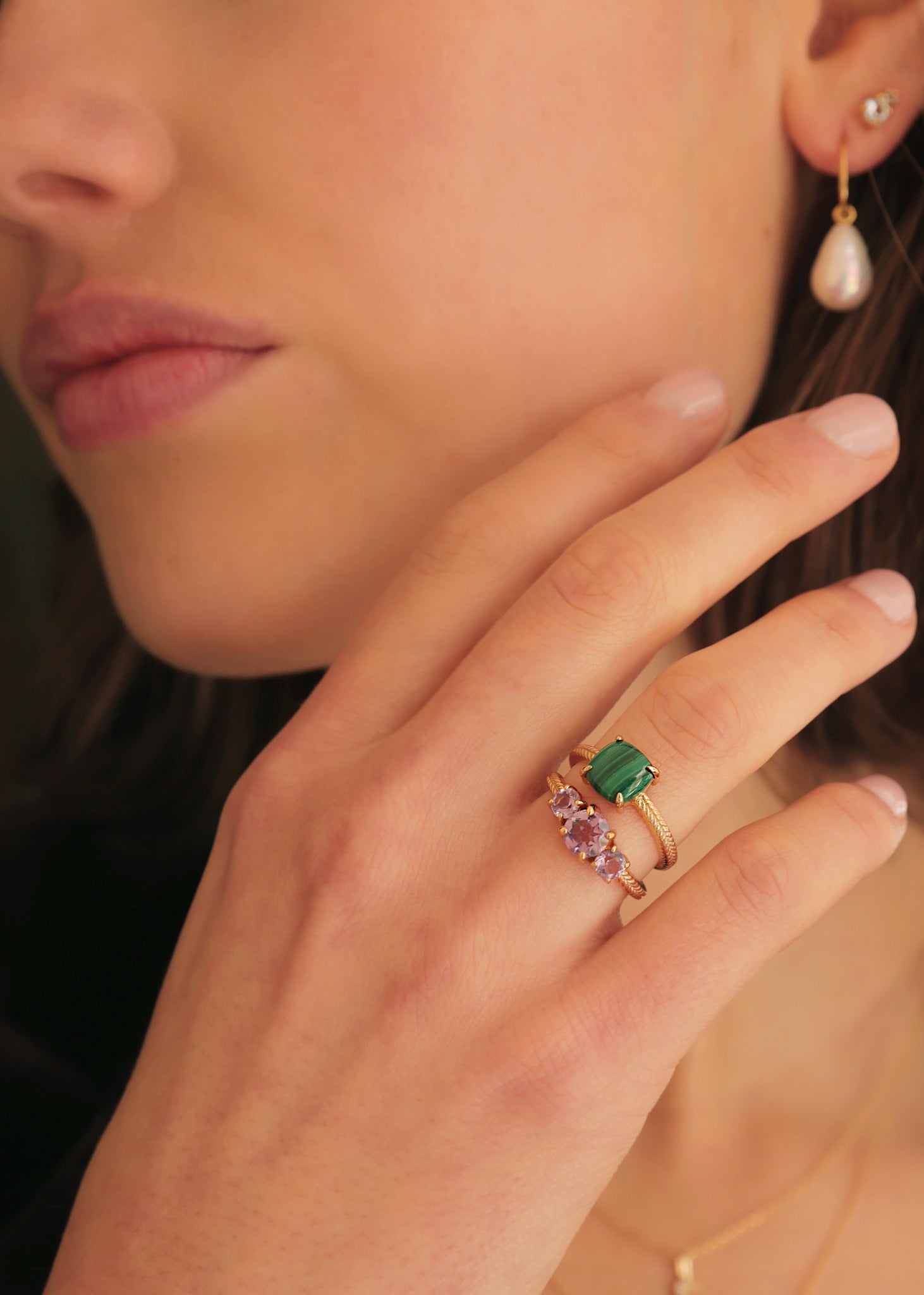 Kvinde med to guld ringe fra carré jewellery med grøn malakit og lilla ametyst ædelsten 