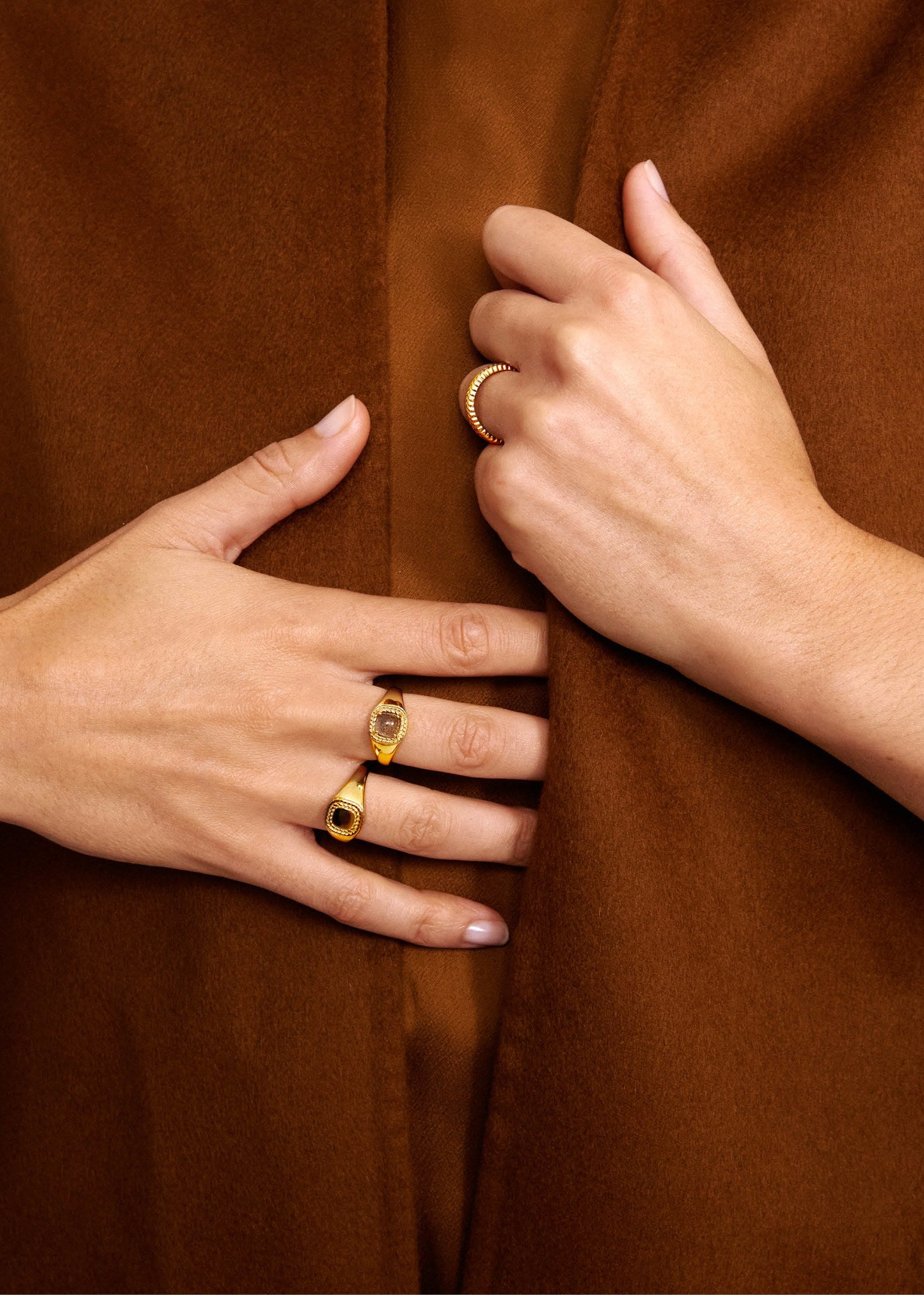Kvinde med ringe fra carré jewellerys mirage kollektion med sildebensmønstre og labradorit ædelsten i guldbelagt sterling sølv