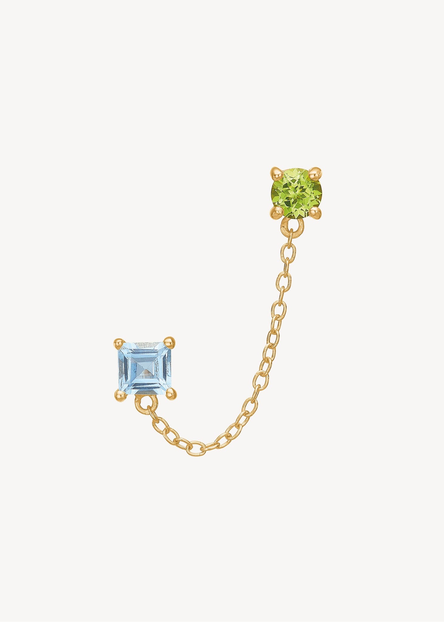 Dobbelt ørestik til to huller i forgyldt sterling sølv med en grøn peridot ædelsten og en blå topas ædelsten og en tynd ankerkæde imellem. Shop øreringe til to huller med ægte farverige ædelsten under 200 kr hos Carré Jewellery 
