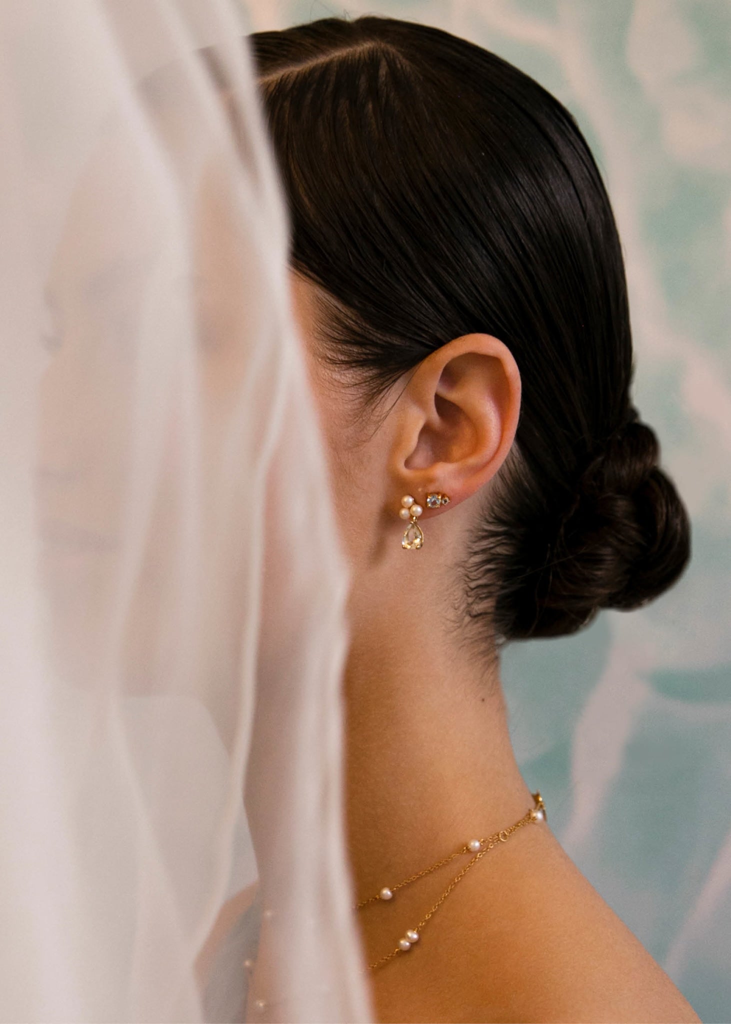 Ung brud med smukke perleøreringe fra carré jewellery med tre ferskvandsperler og en grøn prasiolit ædelsten i guld