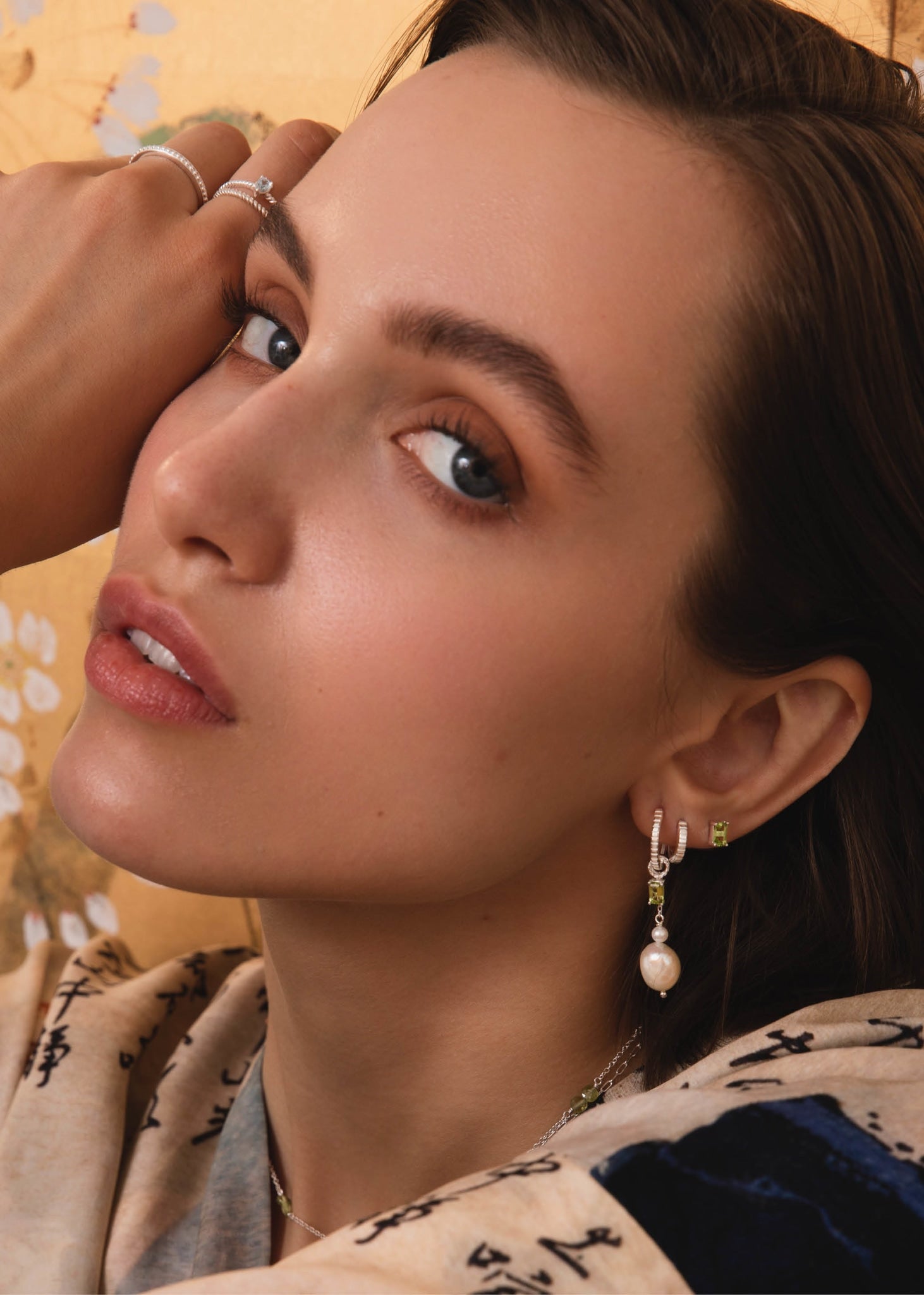 Kvinde med hoops og charms fra carré jewellery i sterling sølv med augusts fødselssten, grøn peridot 