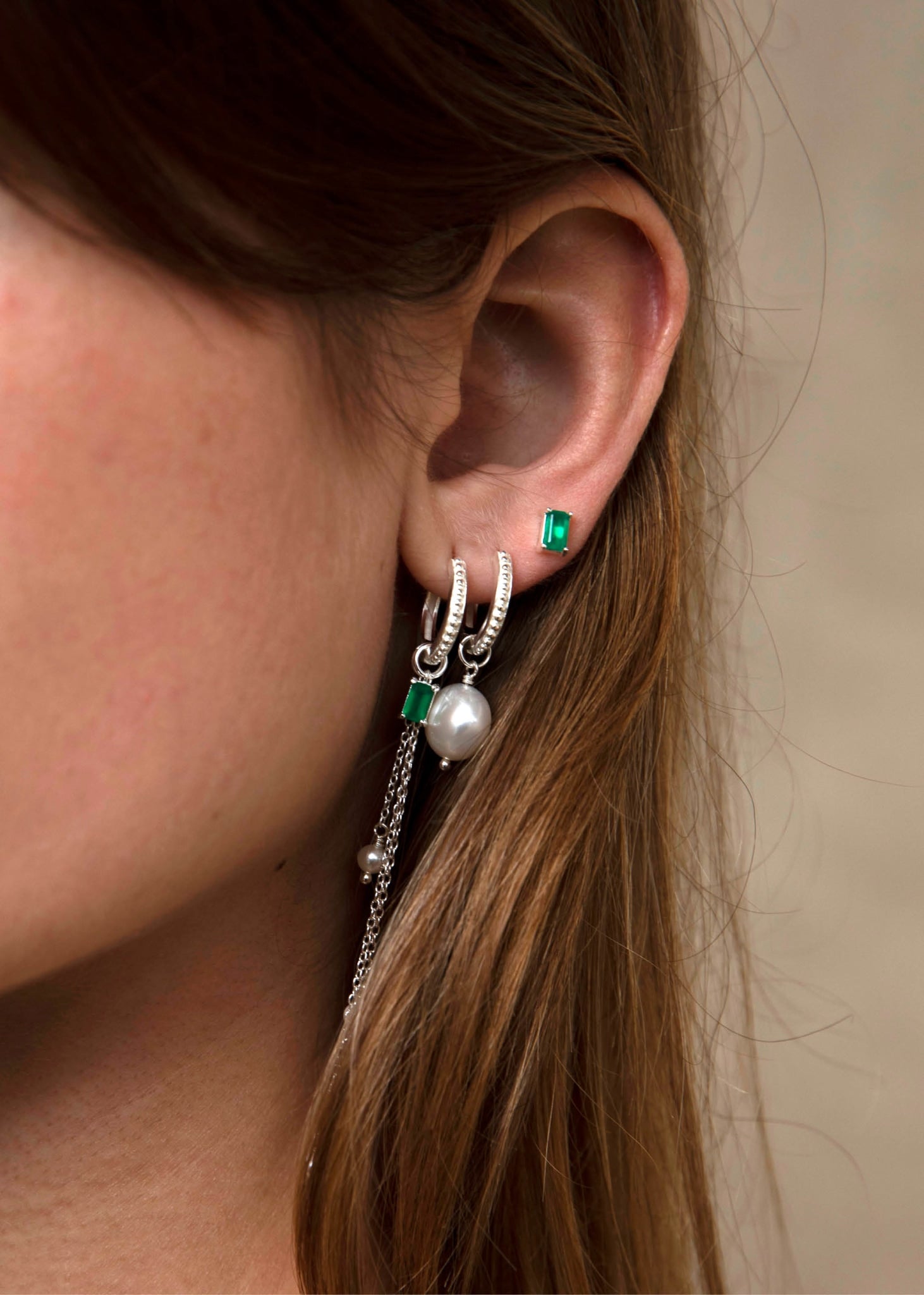 Kvinde med hoops og charms fra carré jewellery med lille ørestik med grøn agat ædelsten i sterling sølv 