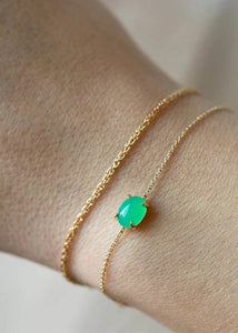 Kvinde med elegante armbånd i ægte guld fra carré jewellery med grønne chrysopras ædelsten på en delikat tynd kæde