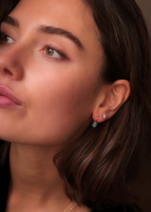 Kvinde med øreringe i ægte 10 karat guld i tournure modellen fra carré jewellery med skinnende labradorit ædelsten 