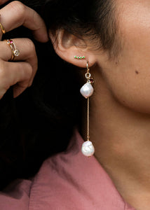 Kvinde med hoops og charms i ægte 10-karat guld fra carré jewellery med ferskvandsperler og en charm med pink turmalin ædelsten