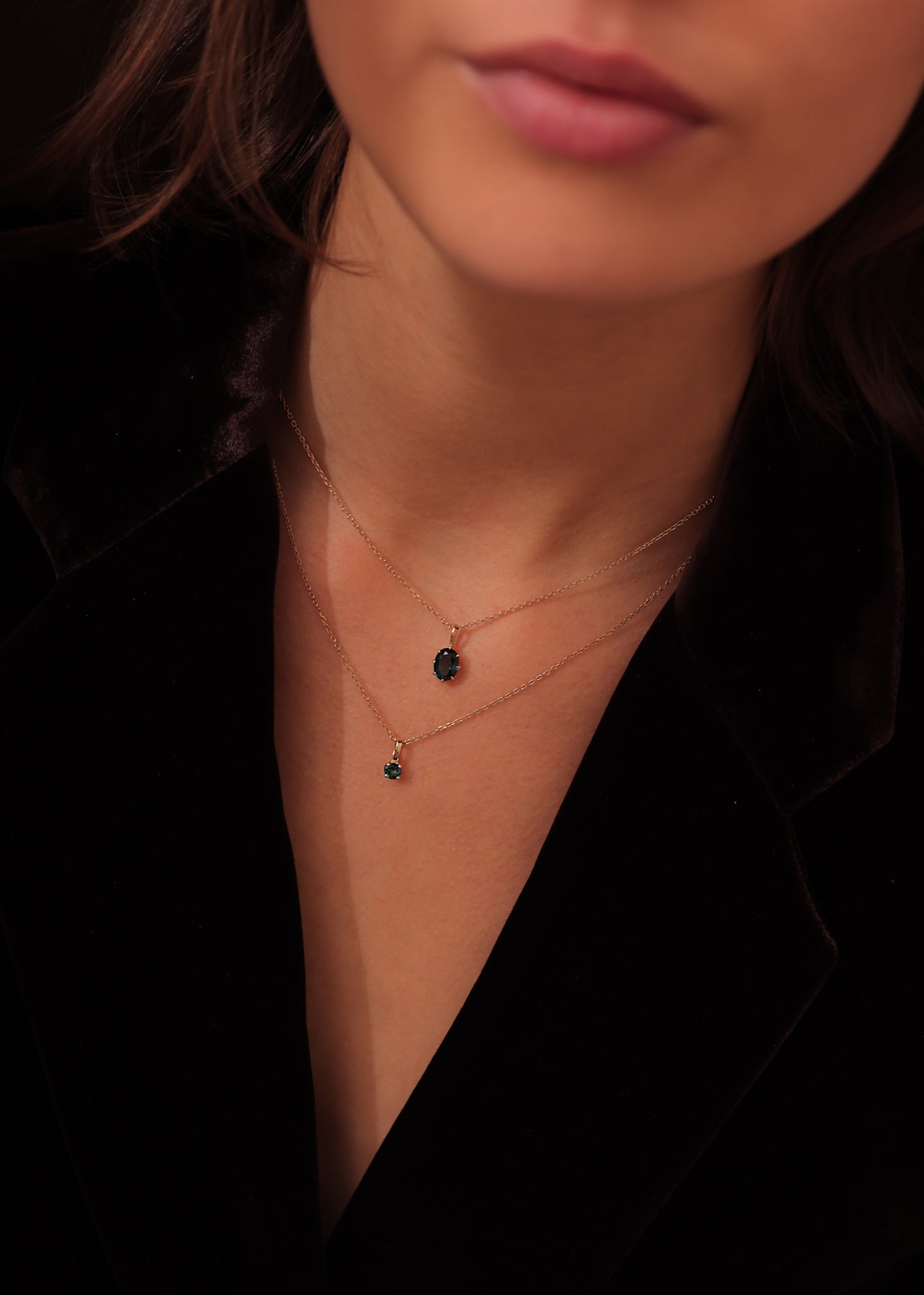 Ung kvinde med halskæder og vedhæng fra carré jewellery i 10 karat guld med london blå topas ædelsten vedhæng til halskæder