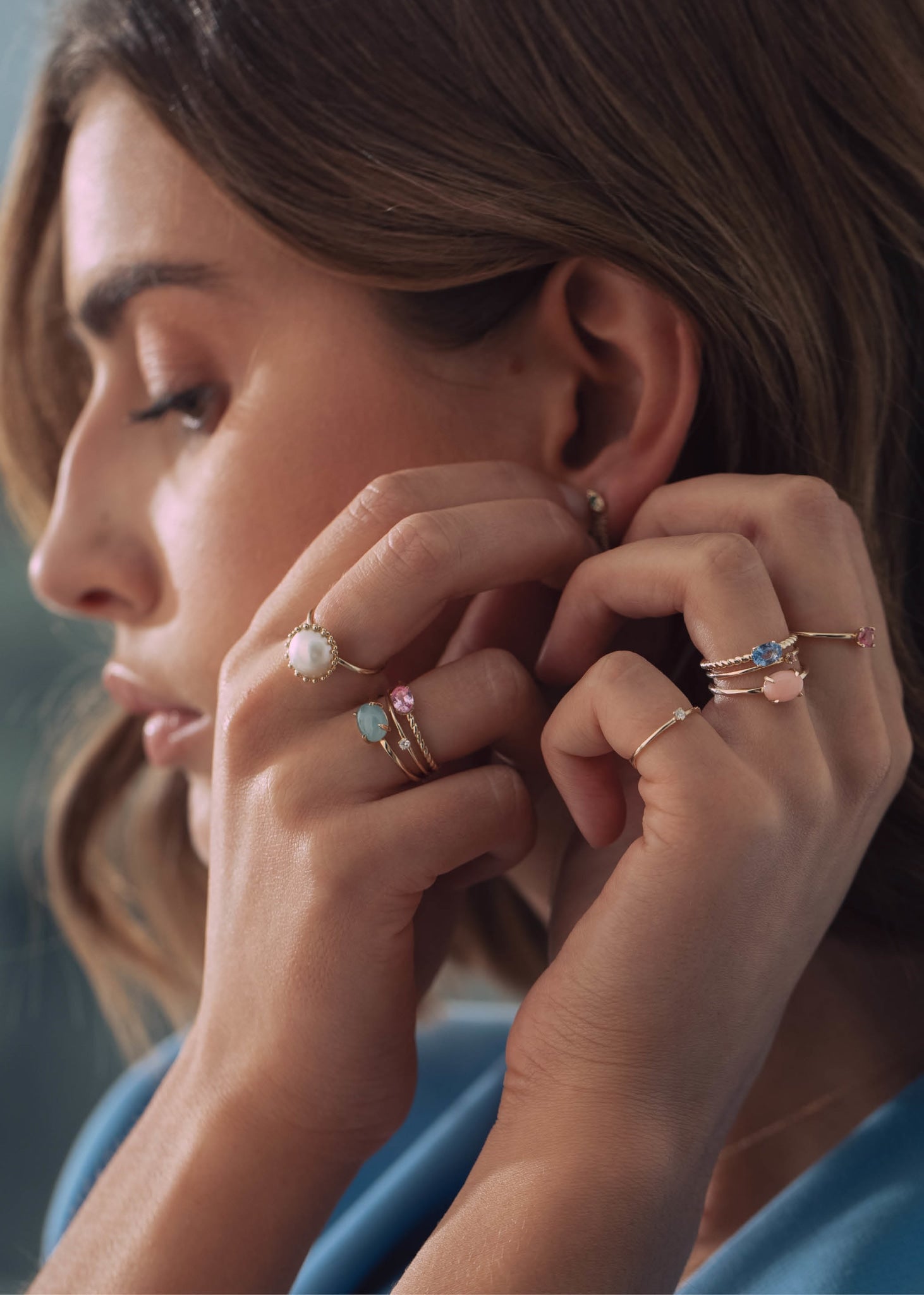 Kvinde med ringe i 10 karat ægte guld med ægte safir, diamant og akvamarin 