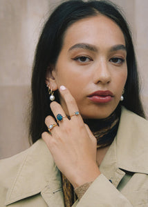 Kvinde med stor statement ring med blå sten i ægte guld sat med ovalslebet london blå topas ædelsten i 10 karat guld 