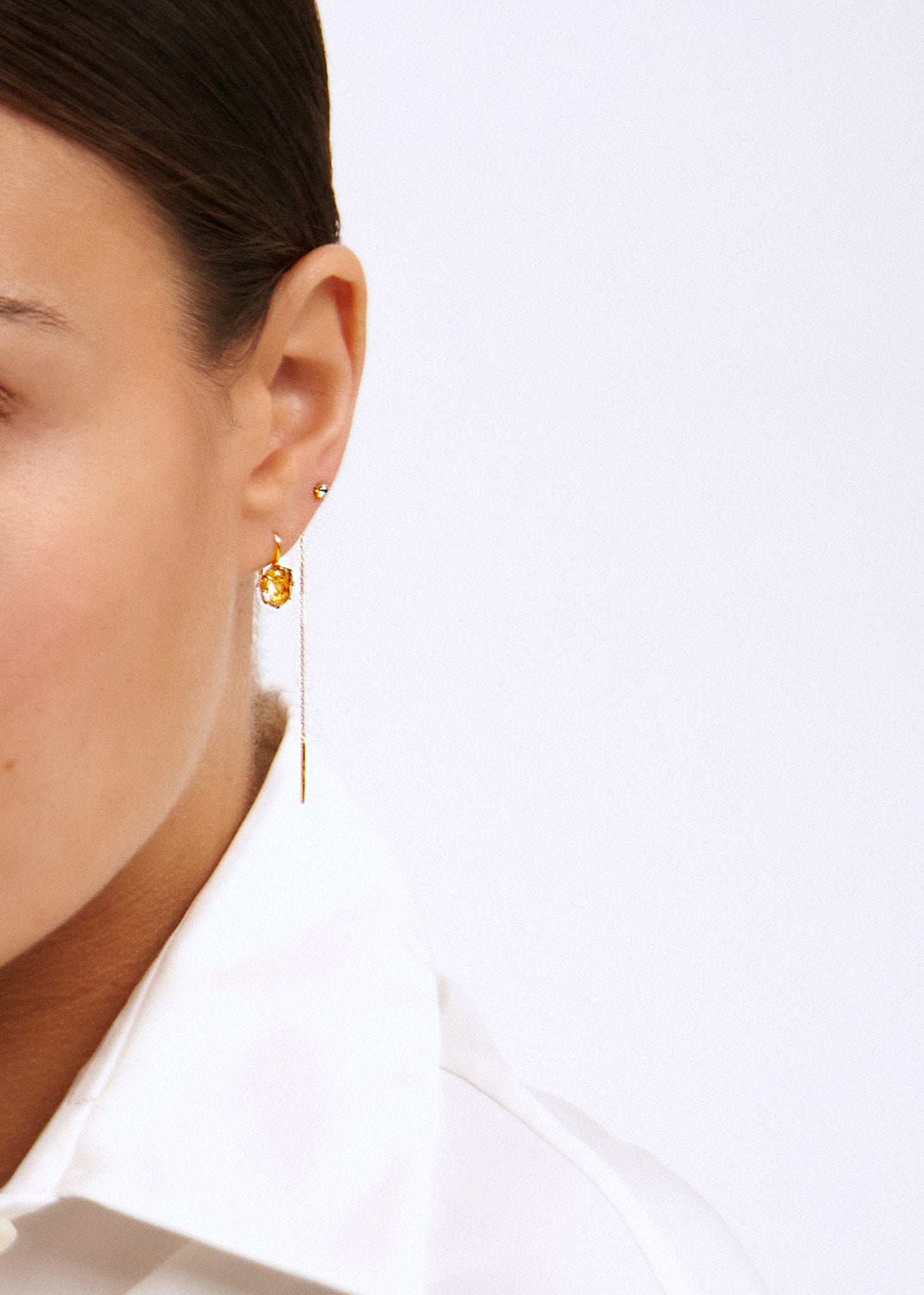 ung kvinde med 10 karat ægte guld øreringe fra carré jewellery med london blå topas ædelsten