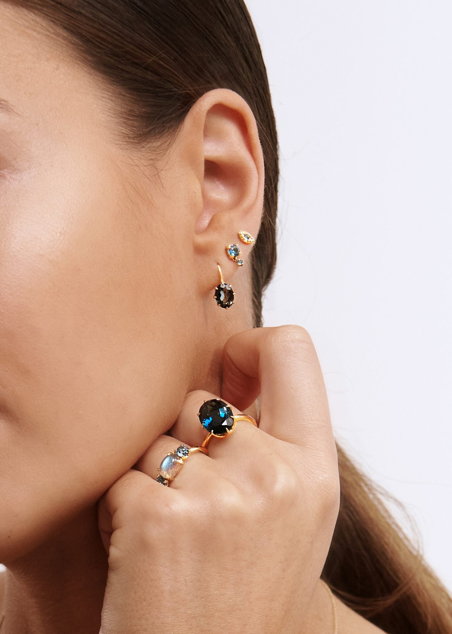 Ung kvinde med øreringe i 10-karat ægte guld med novembers fødselssten, london blå topas ædelsten