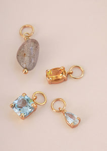 Fire guldbelagte charms fra carré. Charms er sat med en labradorit, en med citrin, og to charms med blå topas.