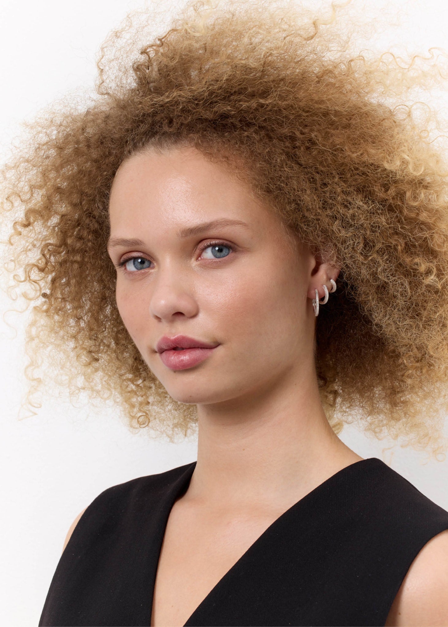 Kvinde med tre sølv hoops fra carré jewellery til hoops og charms med sildebensmønster