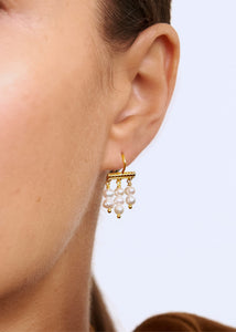 Kvinde med lange perleøreringe fra carré Jewellery i enkel og elegant stil