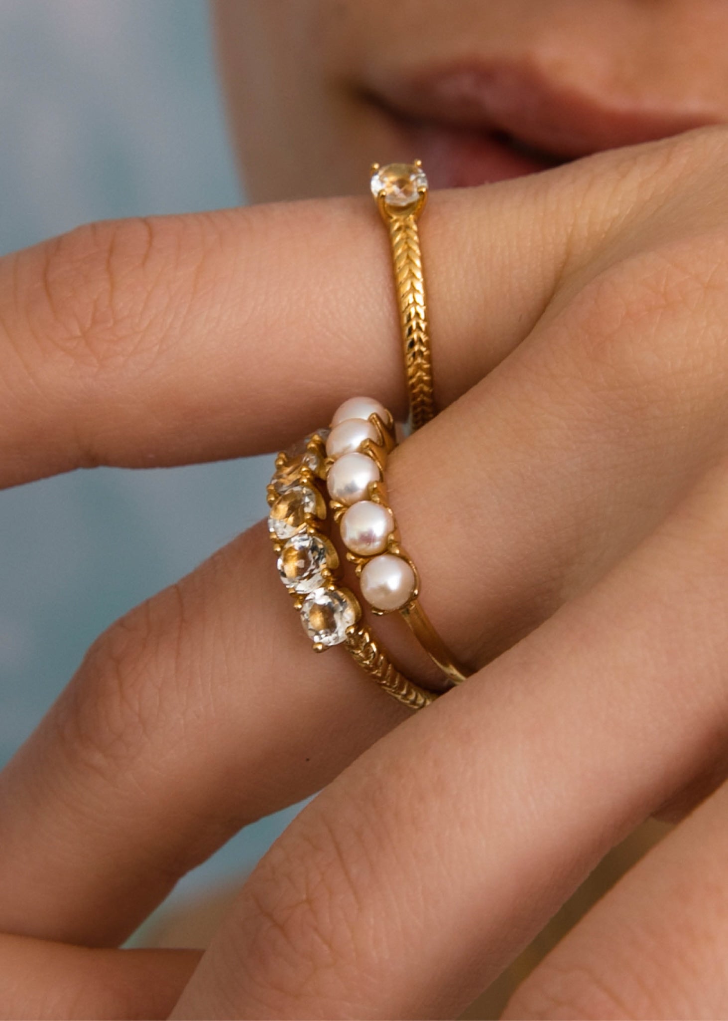 Kvinde med tre guldbelagte sølv ringe fra carré jewellerys reef kollektion med perler og prasiolit