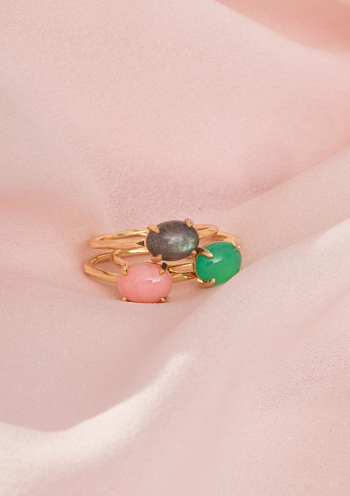 tre 10-karat guld ringe med runde sten fra carré. Ringene er sat med grøn chrysopras, grå labradorit og pink opal