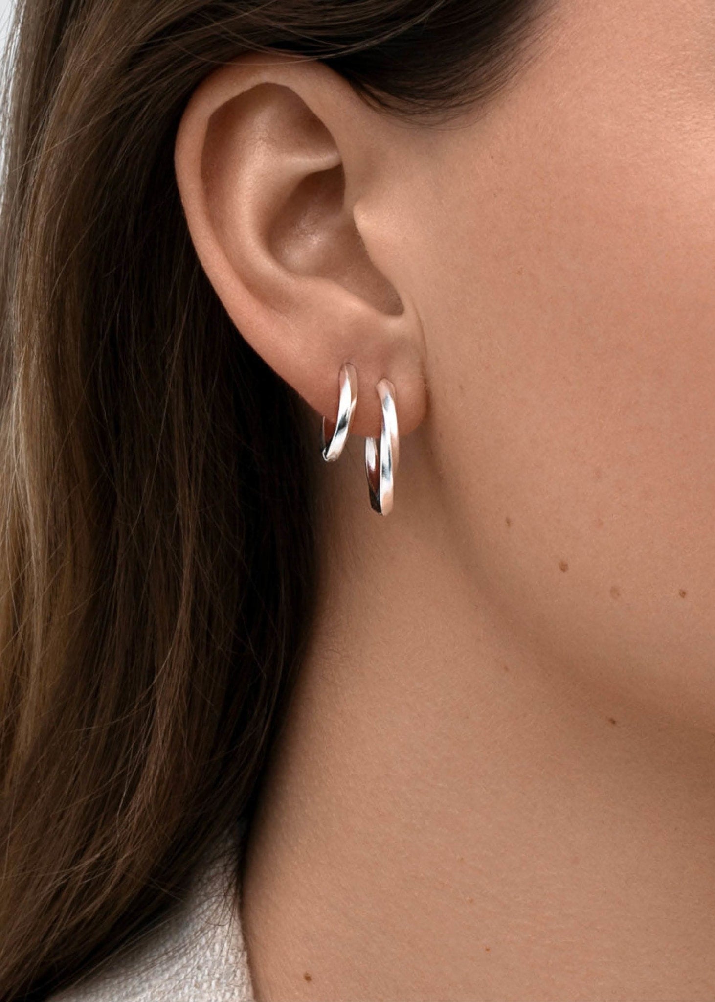 Kvinde med to hoops i snoet design i sterling sølv fra carré jewellery